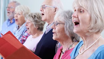 Senioren stehen in einer Reihe und singen | © highwaystarz stock.adobe.com